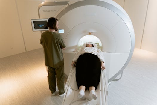 A patient undergoing an MRI scan with a healthcare professional present in a modern medical facility.